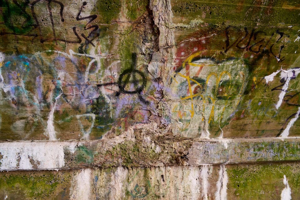 many layers of graffiti on an abandoned bridge arch