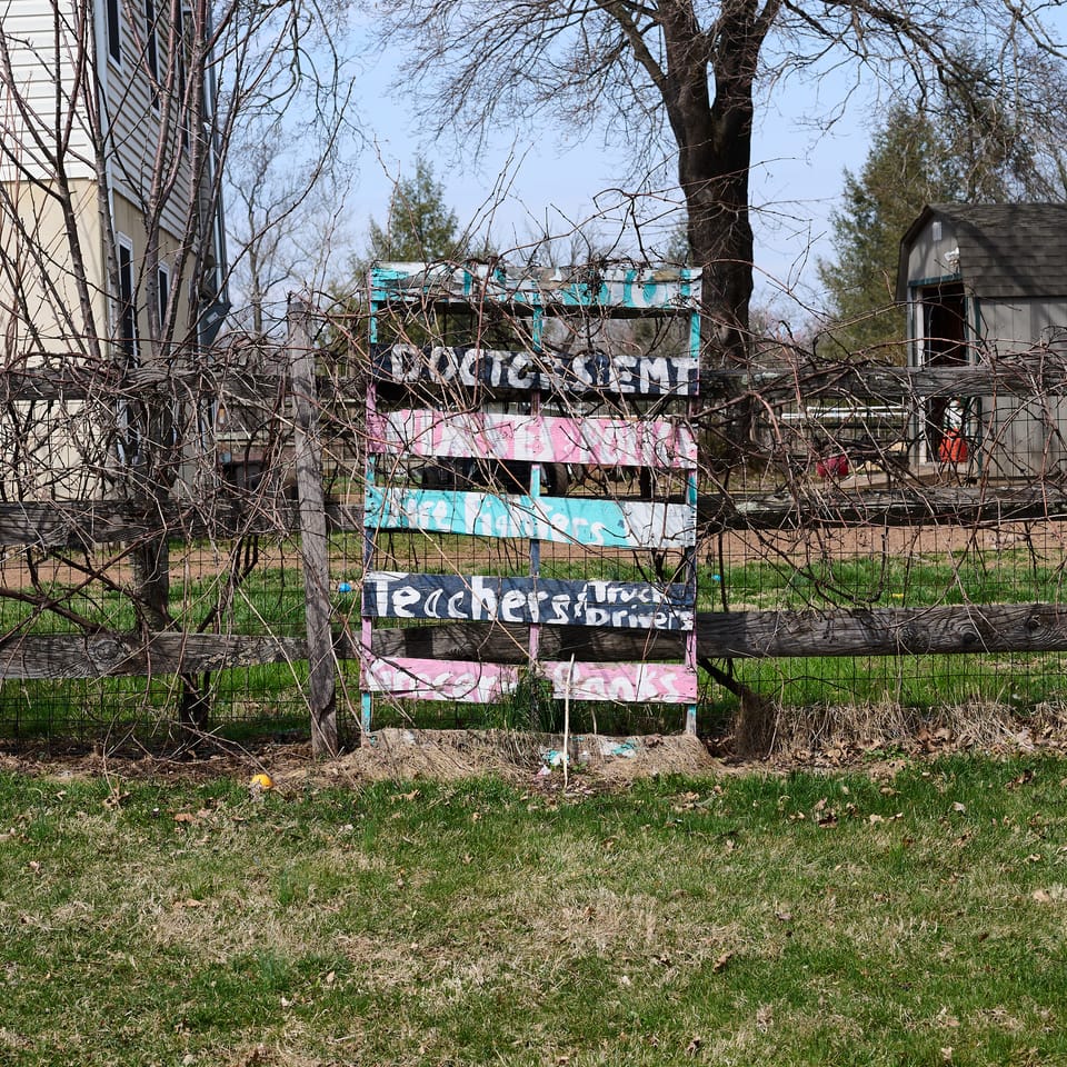 Overgrown sign made from an old wooden pallet